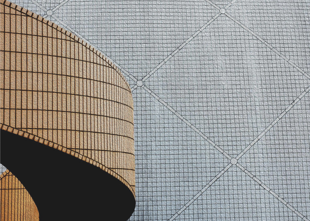 An abstract architectural image with a painterly texture, framed in gray. The composition features a curved wall of vertical brown tiles on the left, casting a sharp black shadow, juxtaposed with a flat surface of gray square tiles arranged in a grid with diagonal lines on the right. Artwork