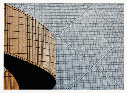 An abstract architectural image with a painterly texture, framed in gray. The composition features a curved wall of vertical brown tiles on the left, casting a sharp black shadow, juxtaposed with a flat surface of gray square tiles arranged in a grid with diagonal lines on the right. Artwork