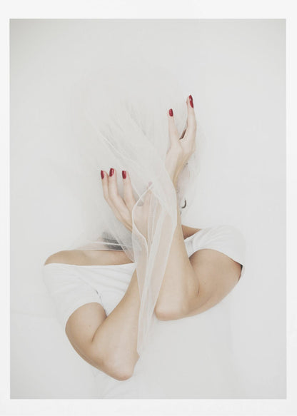 A minimalist photograph of a person in a white t-shirt against a white background, their face hidden by a sheer white veil. Their hands, adorned with bright red nail polish, frame the veiled face in an expressive pose. Wall Art