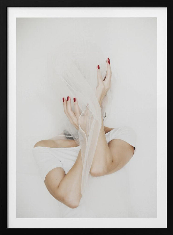 A minimalist photograph of a person in a white t-shirt against a white background, their face hidden by a sheer white veil. Their hands, adorned with bright red nail polish, frame the veiled face in an expressive pose. Wall Art