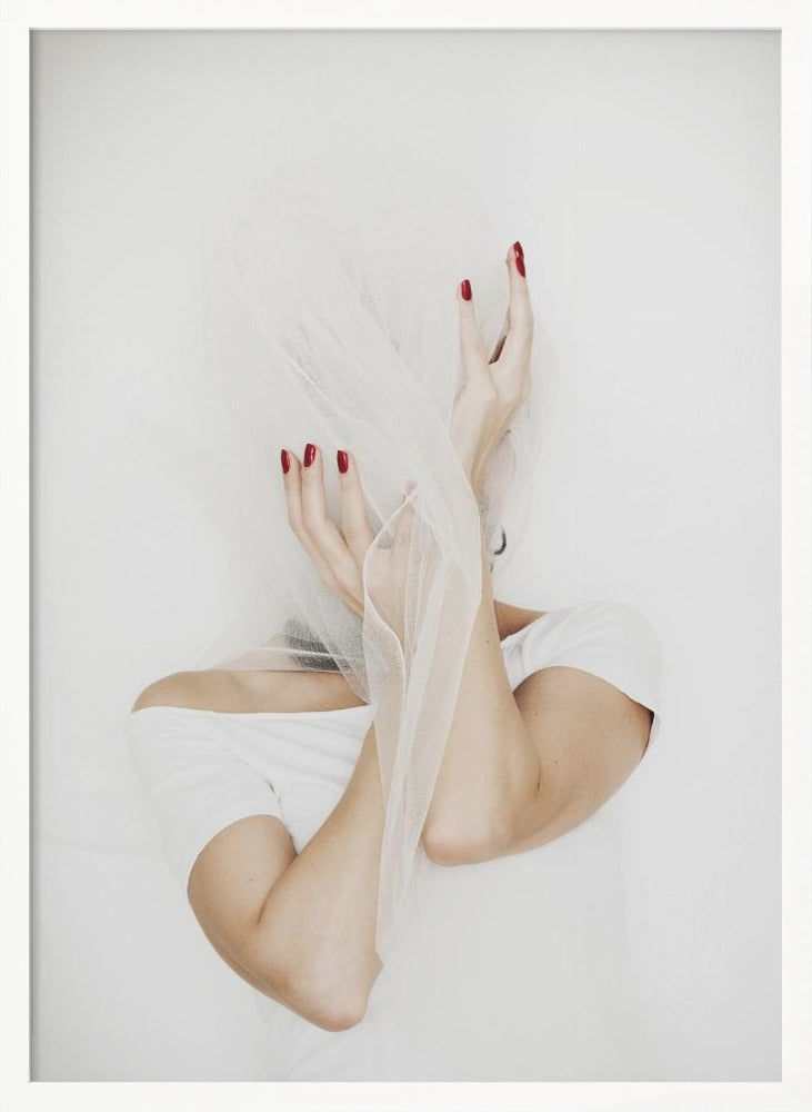 A minimalist photograph of a person in a white t-shirt against a white background, their face hidden by a sheer white veil. Their hands, adorned with bright red nail polish, frame the veiled face in an expressive pose. Wall Art