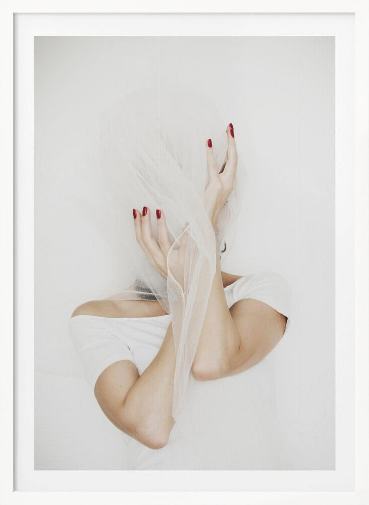 A minimalist photograph of a person in a white t-shirt against a white background, their face hidden by a sheer white veil. Their hands, adorned with bright red nail polish, frame the veiled face in an expressive pose. Wall Art