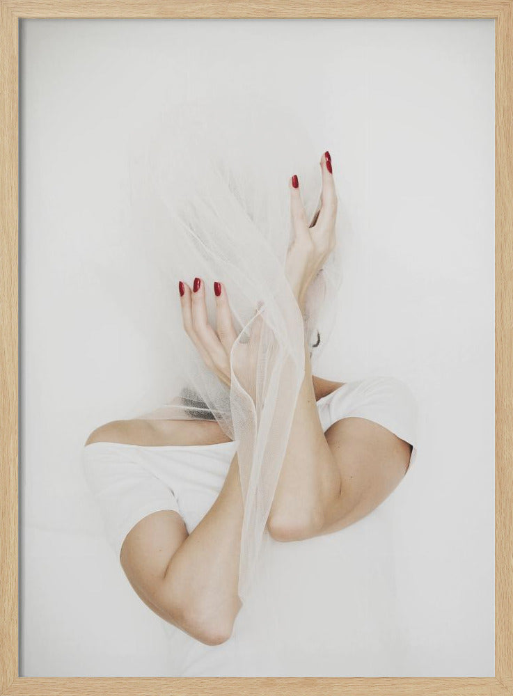 A minimalist photograph of a person in a white t-shirt against a white background, their face hidden by a sheer white veil. Their hands, adorned with bright red nail polish, frame the veiled face in an expressive pose. Wall Art