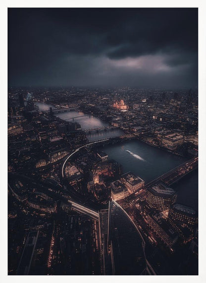 An aerial photograph of London at night from a high vantage point, overlooking the winding River Thames illuminated by the golden glow of city lights under a dark, dramatic, and cloudy sky. Wall Art