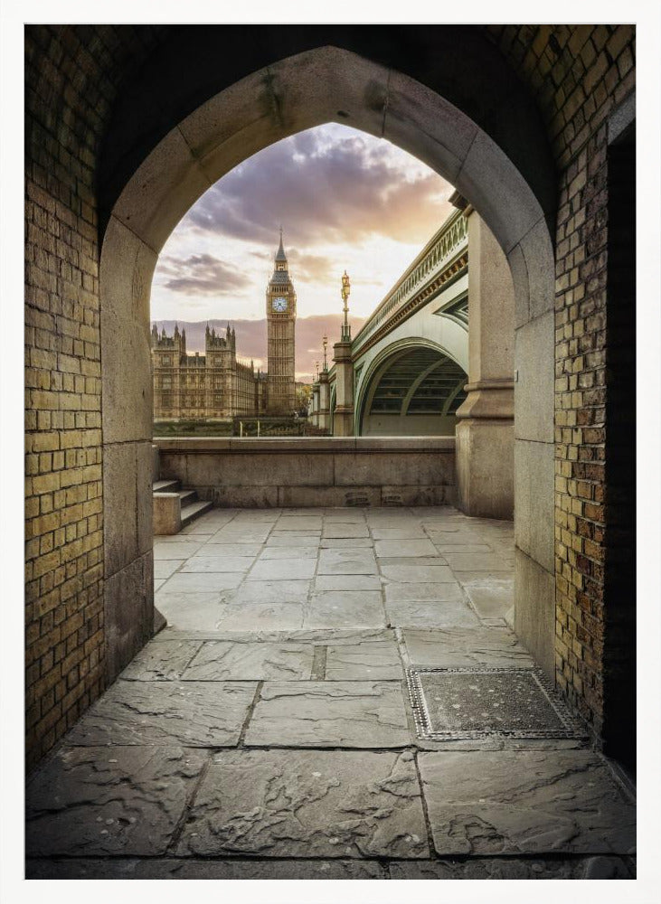 A scenic view of London's Big Ben clock tower and the Houses of Parliament as seen through a weathered stone archway. The foreground features a stone-paved walkway, and the background shows the iconic landmarks against a cloudy sunset sky with hues of purple and orange. Poster