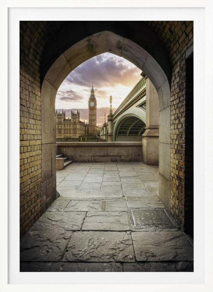A scenic view of London's Big Ben clock tower and the Houses of Parliament as seen through a weathered stone archway. The foreground features a stone-paved walkway, and the background shows the iconic landmarks against a cloudy sunset sky with hues of purple and orange. Poster