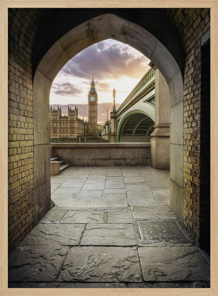 A scenic view of London's Big Ben clock tower and the Houses of Parliament as seen through a weathered stone archway. The foreground features a stone-paved walkway, and the background shows the iconic landmarks against a cloudy sunset sky with hues of purple and orange. Poster