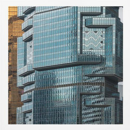 A framed close-up photograph of modern architecture, featuring a golden grid-patterned skyscraper next to a complex blue glass building with jutting levels and distorted reflections. Wall Art