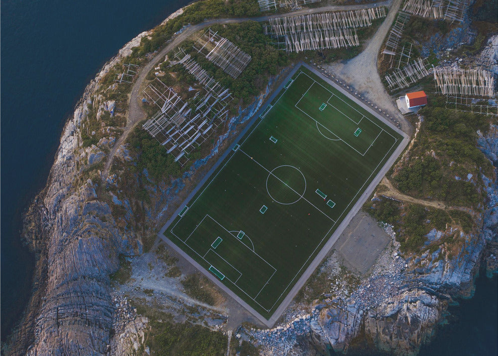 An art print featuring a distant view of a football field under a wide sky, evoking a sense of space and tranquility. Wall Art