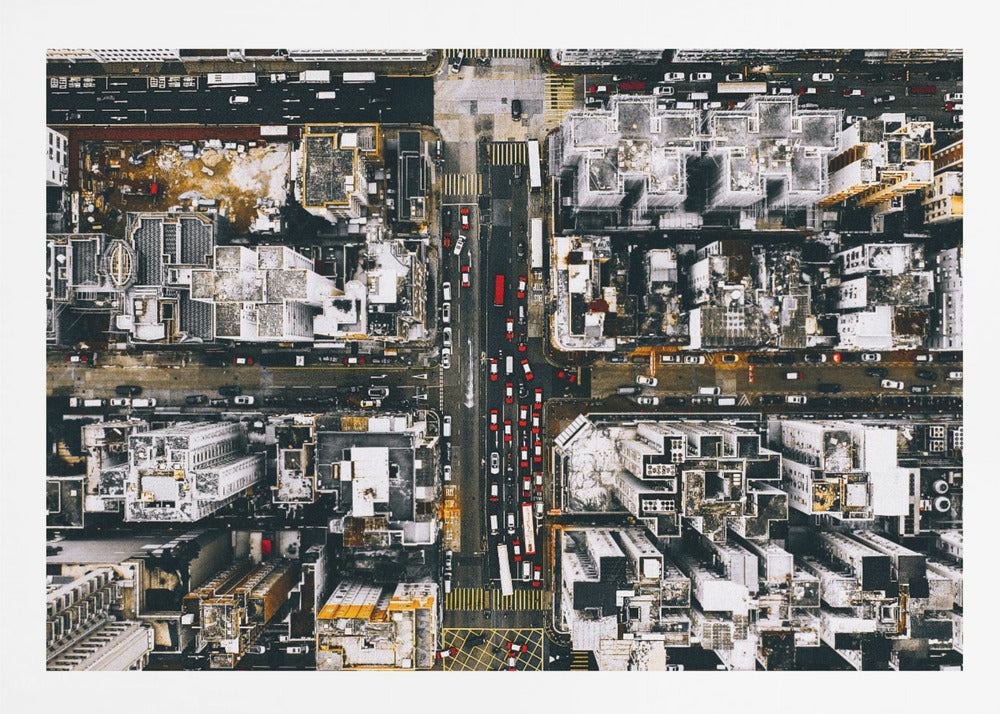 A framed, top-down aerial photo of a dense city grid. The monochromatic scene of white rooftops and dark streets is punctuated by the red and white cars creating lines of traffic below. Decor