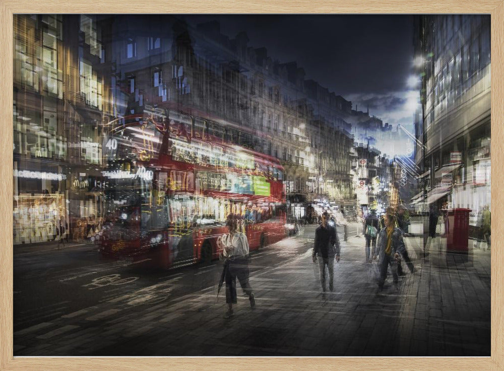 A long-exposure, artistic photograph of a busy London street at night. The motion of a red double-decker bus and pedestrians creates a blurred, ghost-like effect, capturing the vibrant energy of the city. The scene is illuminated by streetlights and building windows, all set within a silver frame. Artwork
