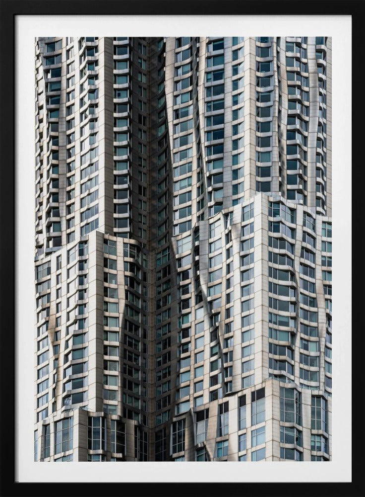 A close-up photograph of the facade of a modern skyscraper with an undulating, wave-like metallic exterior. The building is filled with windows that reflect the light, creating a dynamic pattern of highlights and shadows, all captured within a black frame. Print