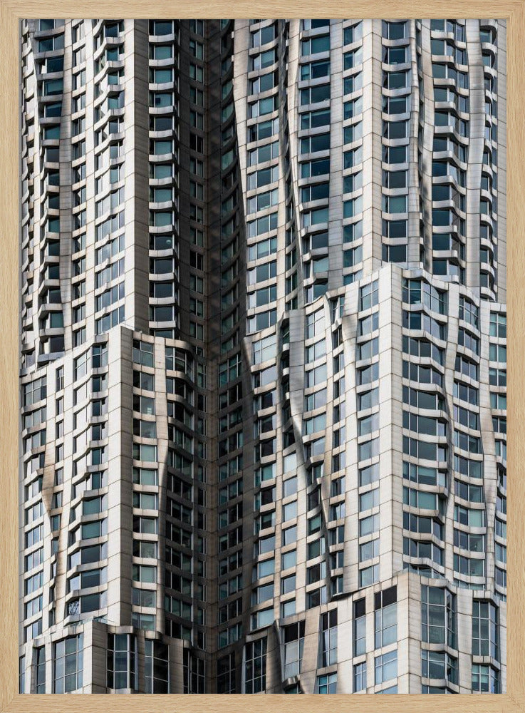 A close-up photograph of the facade of a modern skyscraper with an undulating, wave-like metallic exterior. The building is filled with windows that reflect the light, creating a dynamic pattern of highlights and shadows, all captured within a black frame. Print