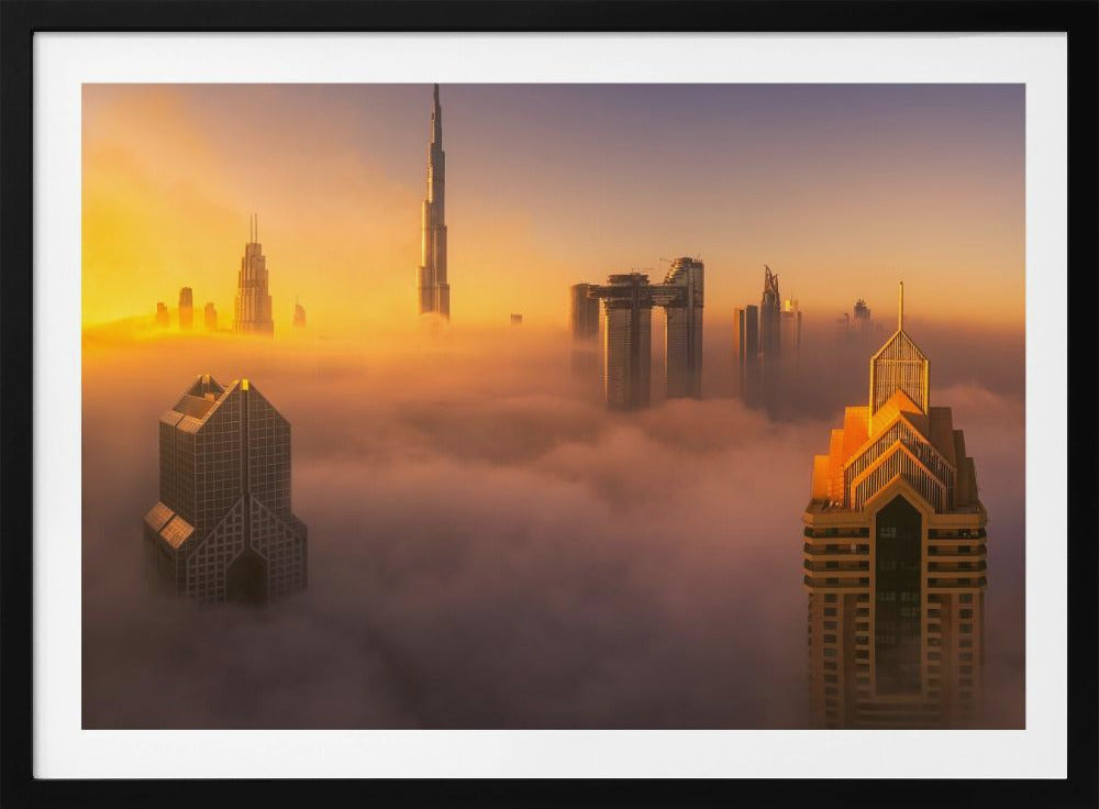 An aerial photograph of the Dubai skyline shrouded in a thick blanket of fog at sunrise. The warm golden light illuminates the tops of several skyscrapers, including the Burj Khalifa, which pierce through the clouds creating a dreamlike and majestic scene. Print