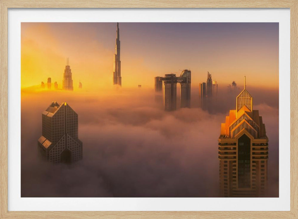 An aerial photograph of the Dubai skyline shrouded in a thick blanket of fog at sunrise. The warm golden light illuminates the tops of several skyscrapers, including the Burj Khalifa, which pierce through the clouds creating a dreamlike and majestic scene. Print