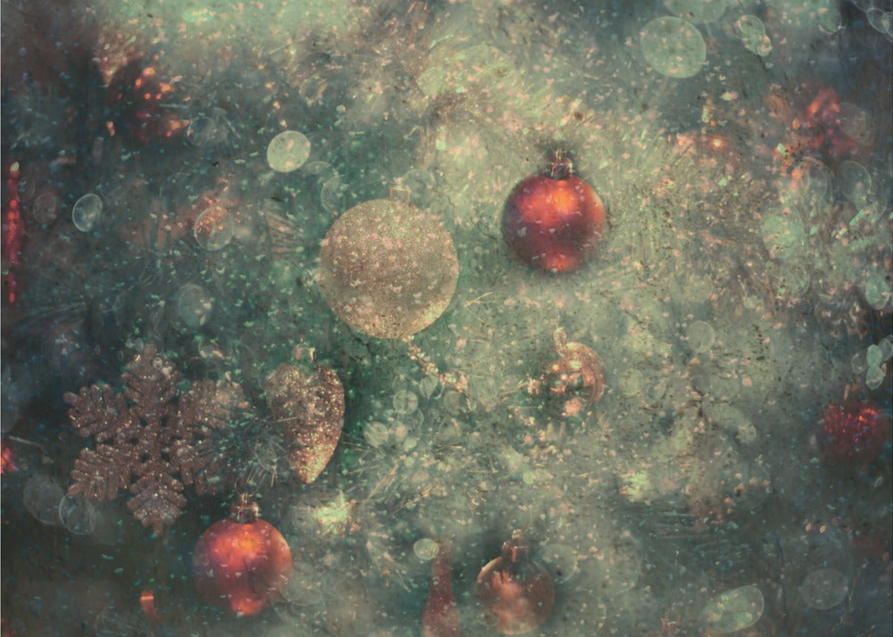 A vintage-style, textured image of Christmas ornaments on a tree, including red and gold baubles and a snowflake. The artwork has a grunge, distressed feel with soft bokeh lights and is presented in a silver frame. Poster