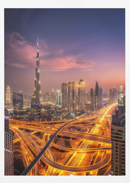A stunning aerial photograph of the Dubai skyline at dusk, featuring the illuminated Burj Khalifa against a purple and pink sunset sky. In the foreground, complex highway interchanges are aglow with the golden-orange light trails of moving traffic, creating a sense of vibrant energy. Poster