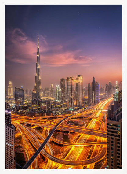 A stunning aerial photograph of the Dubai skyline at dusk, featuring the illuminated Burj Khalifa against a purple and pink sunset sky. In the foreground, complex highway interchanges are aglow with the golden-orange light trails of moving traffic, creating a sense of vibrant energy. Poster