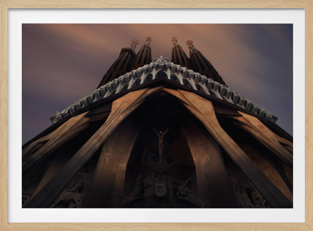 A dramatic, low-angle shot of the Sagrada Familia cathedral, focusing on the intricate details of the Passion Facade against a dusky purple and orange sky. The spires tower above, while deep shadows highlight the unique, angled columns and the central sculpture of the crucifixion. Poster