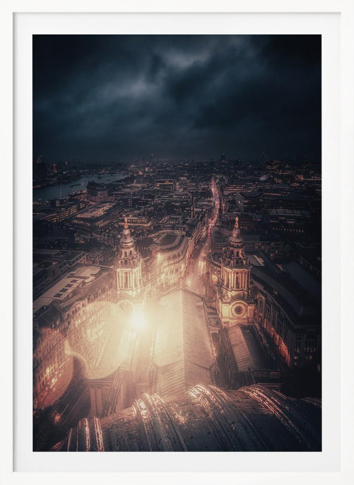 A dramatic, high-angle nighttime photograph of a sprawling city, likely London, viewed from the top of a cathedral. The foreground shows the curved dome, while below, two towers and the long roof of the church are brightly illuminated. The city stretches into the distance with countless golden lights under a dark, stormy, and cloud-filled sky. Poster