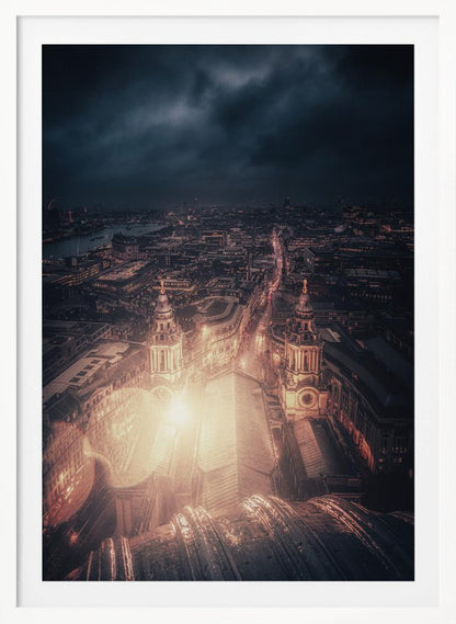 A dramatic, high-angle nighttime photograph of a sprawling city, likely London, viewed from the top of a cathedral. The foreground shows the curved dome, while below, two towers and the long roof of the church are brightly illuminated. The city stretches into the distance with countless golden lights under a dark, stormy, and cloud-filled sky. Poster