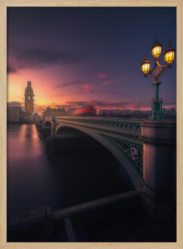 A breathtaking twilight view of Westminster Bridge in London, with the iconic Big Ben illuminated in the background against a purple and orange sunset sky. A vintage street lamp glows warmly in the foreground, and the motion blur of a red bus crosses the bridge over the calm River Thames. Print