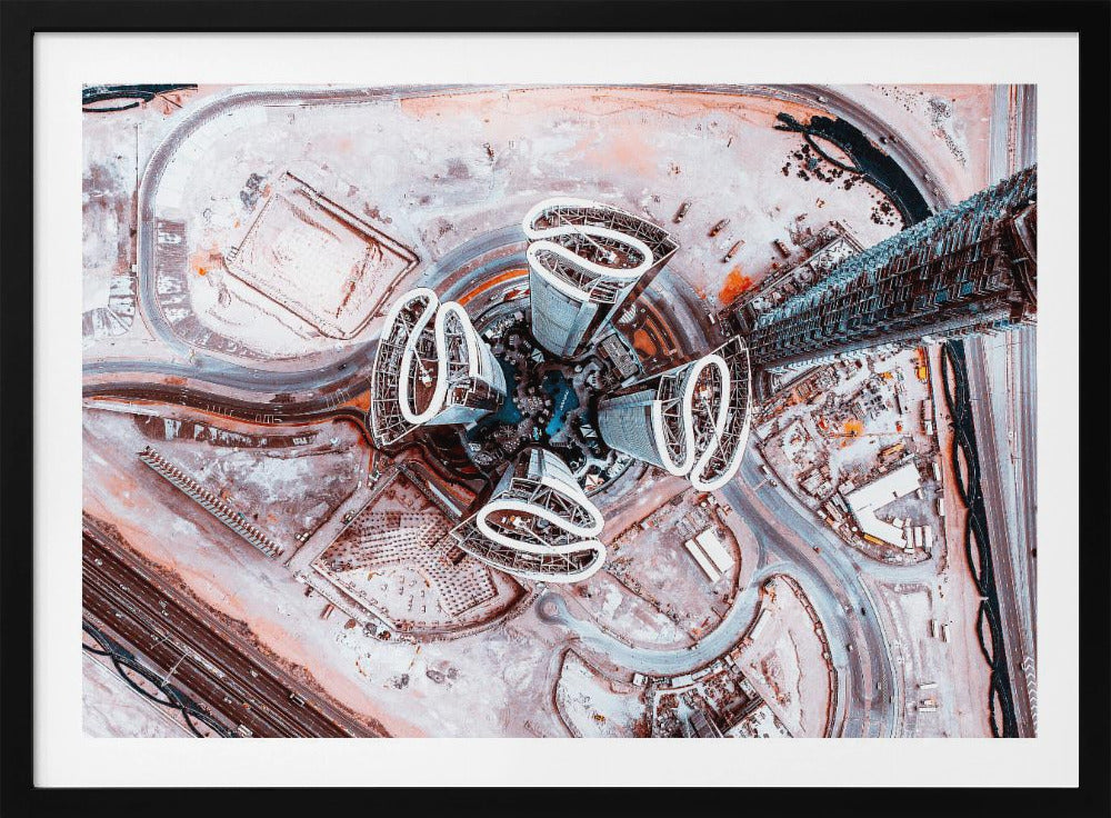 A dizzying top-down aerial photograph of five futuristic, petal-shaped skyscrapers surrounding a central turquoise pool. The surrounding urban landscape is a mix of dusty pink construction sites and curving roads, creating a surreal and abstract cityscape. Wall Art