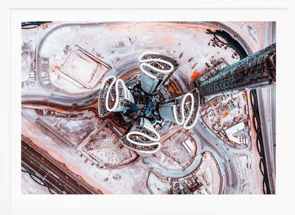 A dizzying top-down aerial photograph of five futuristic, petal-shaped skyscrapers surrounding a central turquoise pool. The surrounding urban landscape is a mix of dusty pink construction sites and curving roads, creating a surreal and abstract cityscape. Wall Art