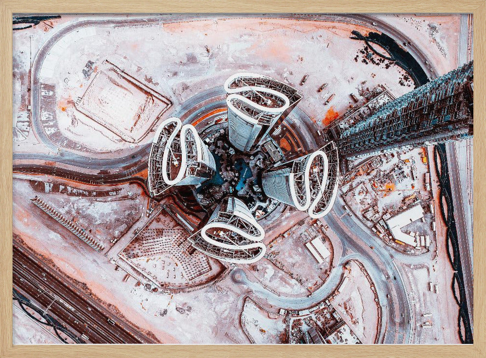A dizzying top-down aerial photograph of five futuristic, petal-shaped skyscrapers surrounding a central turquoise pool. The surrounding urban landscape is a mix of dusty pink construction sites and curving roads, creating a surreal and abstract cityscape. Wall Art