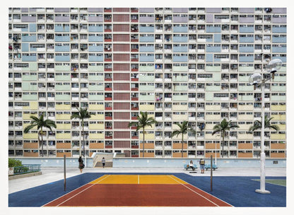 A wide, symmetrical photograph of the colorful Choi Hung Estate apartment building in Hong Kong, featuring a facade with a repeating pattern of pastel blue, green, yellow, and orange blocks. In front of the building is a vibrant basketball court painted in bold sections of blue, red, and yellow, with several palm trees lining the courtyard. Print