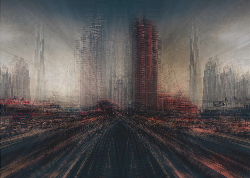 An abstract, moody cityscape artwork in a silver frame. The perspective is from a low angle looking down dark, blurred tracks towards a horizon of towering, distorted skyscrapers under a dark, hazy sky. The color scheme is dominated by dark grays, blacks, and pops of intense red, creating a sense of rapid motion and a dystopian, futuristic atmosphere. Artwork