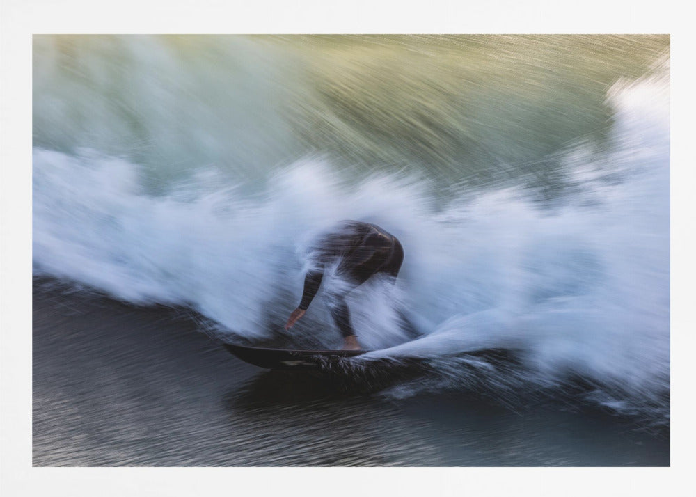 An abstract, motion-blur photograph of a surfer in a black wetsuit, crouched on their board and surrounded by a dynamic swirl of white sea spray and dark blue water, all enclosed in a silver frame. Artwork