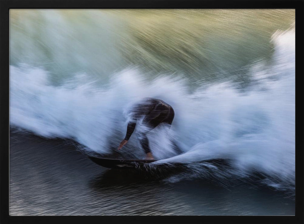 An abstract, motion-blur photograph of a surfer in a black wetsuit, crouched on their board and surrounded by a dynamic swirl of white sea spray and dark blue water, all enclosed in a silver frame. Artwork