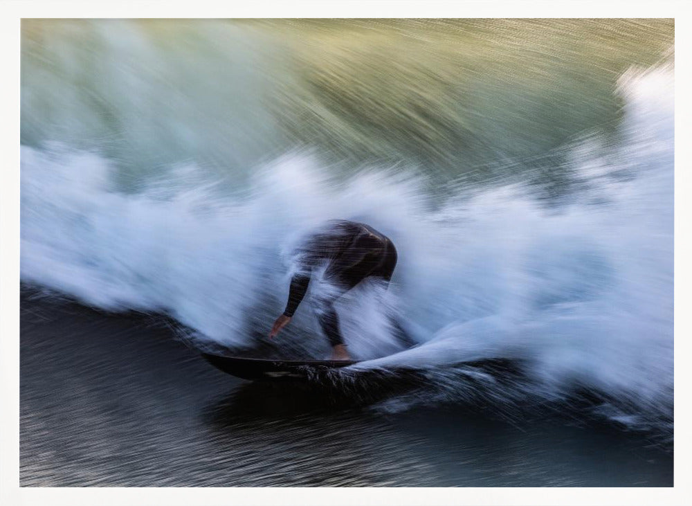 An abstract, motion-blur photograph of a surfer in a black wetsuit, crouched on their board and surrounded by a dynamic swirl of white sea spray and dark blue water, all enclosed in a silver frame. Artwork