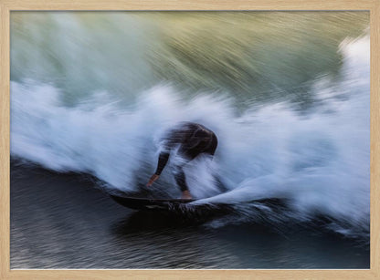 An abstract, motion-blur photograph of a surfer in a black wetsuit, crouched on their board and surrounded by a dynamic swirl of white sea spray and dark blue water, all enclosed in a silver frame. Artwork