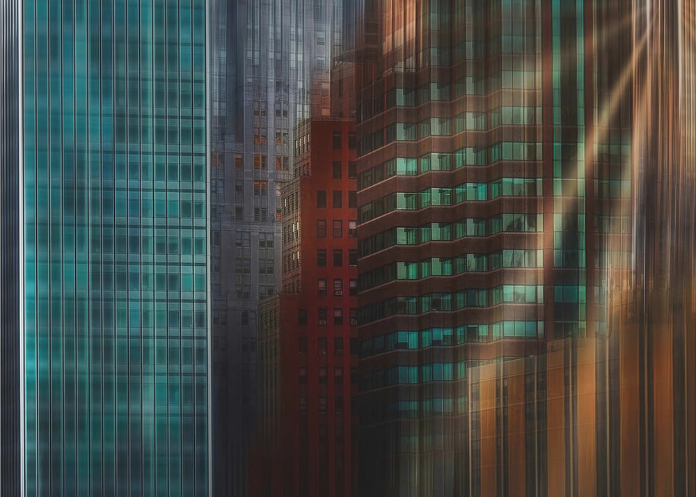 An abstract cityscape artwork in a silver frame, featuring a teal glass skyscraper on the left transitioning to red and brown buildings on the right with a strong vertical motion blur effect, creating a dynamic sense of movement. Decor