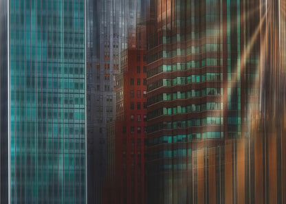 An abstract cityscape artwork in a silver frame, featuring a teal glass skyscraper on the left transitioning to red and brown buildings on the right with a strong vertical motion blur effect, creating a dynamic sense of movement. Decor