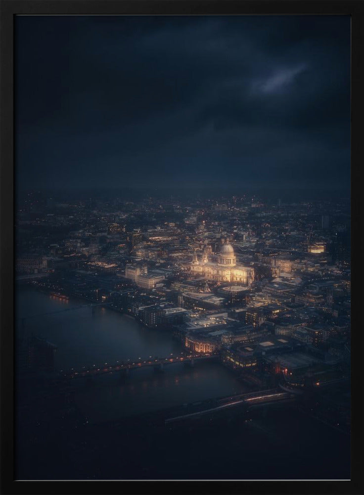 An atmospheric aerial view of London at night, with the illuminated St. Paul's Cathedral as the central focus. The sprawling cityscape glows with warm lights against a dark, stormy sky, while the River Thames flows in the foreground. Wall Art