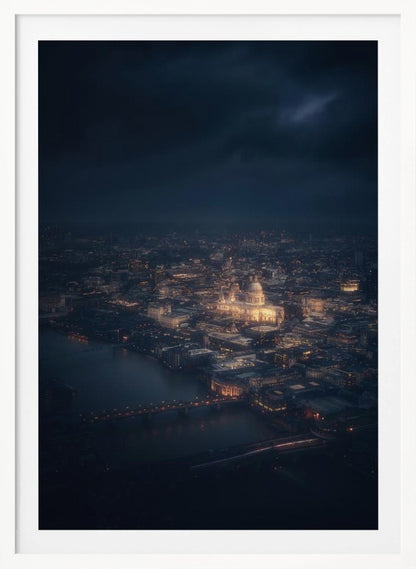 An atmospheric aerial view of London at night, with the illuminated St. Paul's Cathedral as the central focus. The sprawling cityscape glows with warm lights against a dark, stormy sky, while the River Thames flows in the foreground. Wall Art