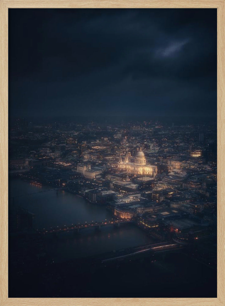 An atmospheric aerial view of London at night, with the illuminated St. Paul's Cathedral as the central focus. The sprawling cityscape glows with warm lights against a dark, stormy sky, while the River Thames flows in the foreground. Wall Art