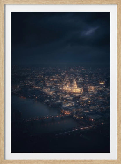 An atmospheric aerial view of London at night, with the illuminated St. Paul's Cathedral as the central focus. The sprawling cityscape glows with warm lights against a dark, stormy sky, while the River Thames flows in the foreground. Wall Art