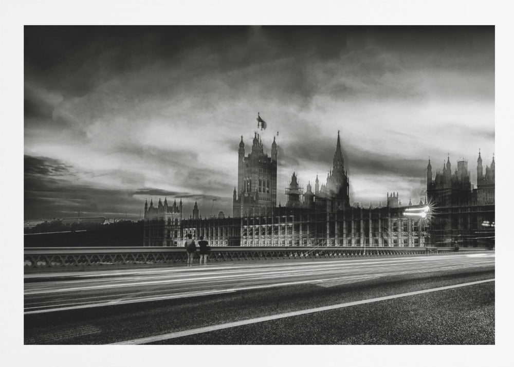 A framed, black and white long-exposure photograph of the Houses of Parliament and Big Ben in London. The view is from a bridge, with streaks of white light from traffic blurring across the road in the foreground under a dramatic, cloudy sky. Wall Art