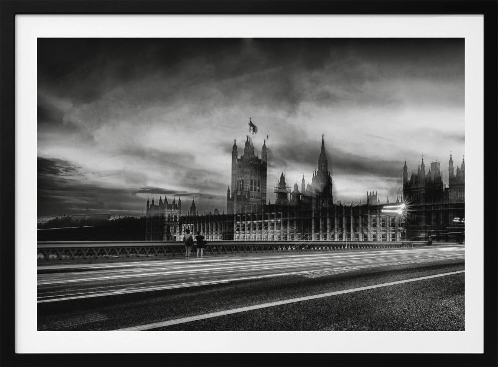 A framed, black and white long-exposure photograph of the Houses of Parliament and Big Ben in London. The view is from a bridge, with streaks of white light from traffic blurring across the road in the foreground under a dramatic, cloudy sky. Wall Art