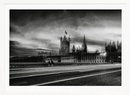 A framed, black and white long-exposure photograph of the Houses of Parliament and Big Ben in London. The view is from a bridge, with streaks of white light from traffic blurring across the road in the foreground under a dramatic, cloudy sky. Wall Art