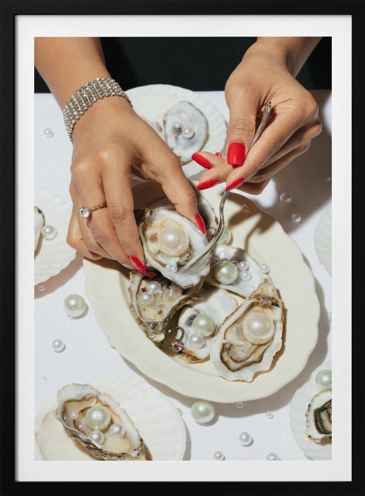 A close-up overhead shot of a woman's hands with vibrant red nails and elegant jewelry, using a fork to lift a large pearl from an oyster shell on a white plate. The plate and the surrounding white surface are adorned with numerous oysters filled with pearls of varying sizes, creating a luxurious and surreal scene. Print