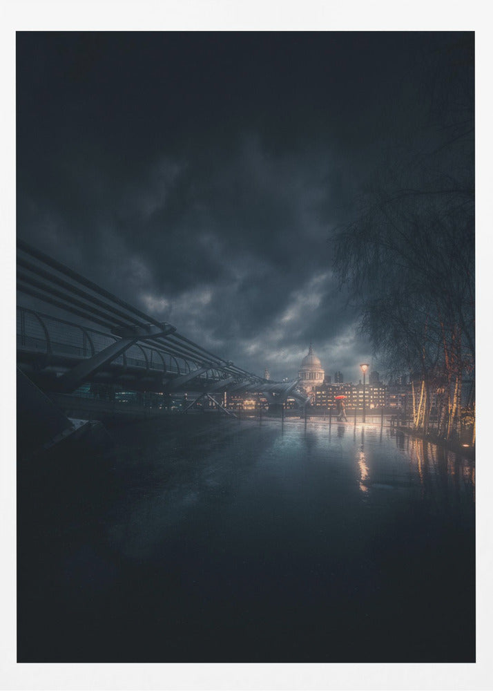 A moody, atmospheric night photograph of London, featuring the Millennium Bridge stretching across a wet surface towards the illuminated St. Paul's Cathedral under a dark, stormy sky. City lights reflect on the wet ground, and trees with warm lights line the right side of the frame. Artwork