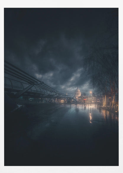 A moody, atmospheric night photograph of London, featuring the Millennium Bridge stretching across a wet surface towards the illuminated St. Paul's Cathedral under a dark, stormy sky. City lights reflect on the wet ground, and trees with warm lights line the right side of the frame. Artwork