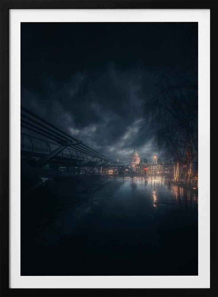 A moody, atmospheric night photograph of London, featuring the Millennium Bridge stretching across a wet surface towards the illuminated St. Paul's Cathedral under a dark, stormy sky. City lights reflect on the wet ground, and trees with warm lights line the right side of the frame. Artwork