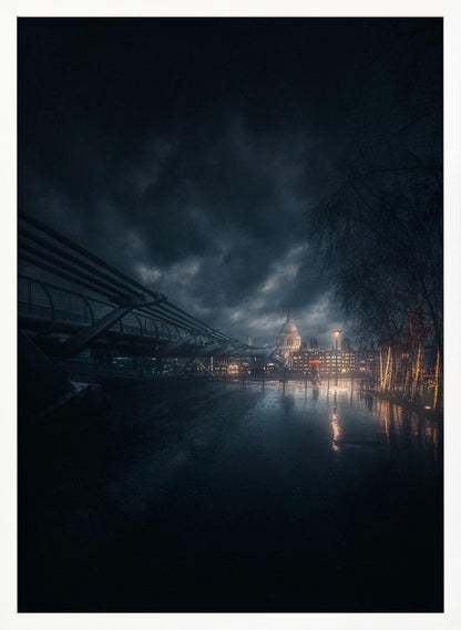 A moody, atmospheric night photograph of London, featuring the Millennium Bridge stretching across a wet surface towards the illuminated St. Paul's Cathedral under a dark, stormy sky. City lights reflect on the wet ground, and trees with warm lights line the right side of the frame. Artwork