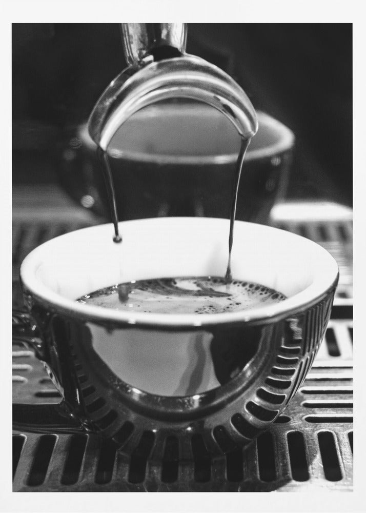A close-up, black and white artistic photograph capturing the moment two streams of dark espresso pour from a portafilter into a waiting cup on a coffee machine's drip tray. Wall Art